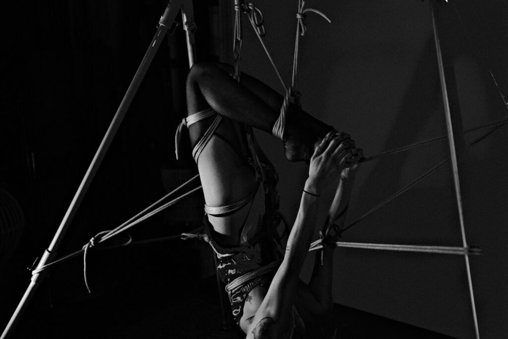 A woman hanging upside down on a pole