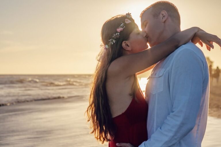 Couple sharing a romantic kiss at sunset on the beach
