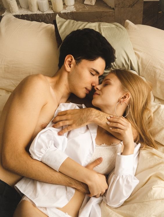 Couple embracing in a warm intimate bedroom setting